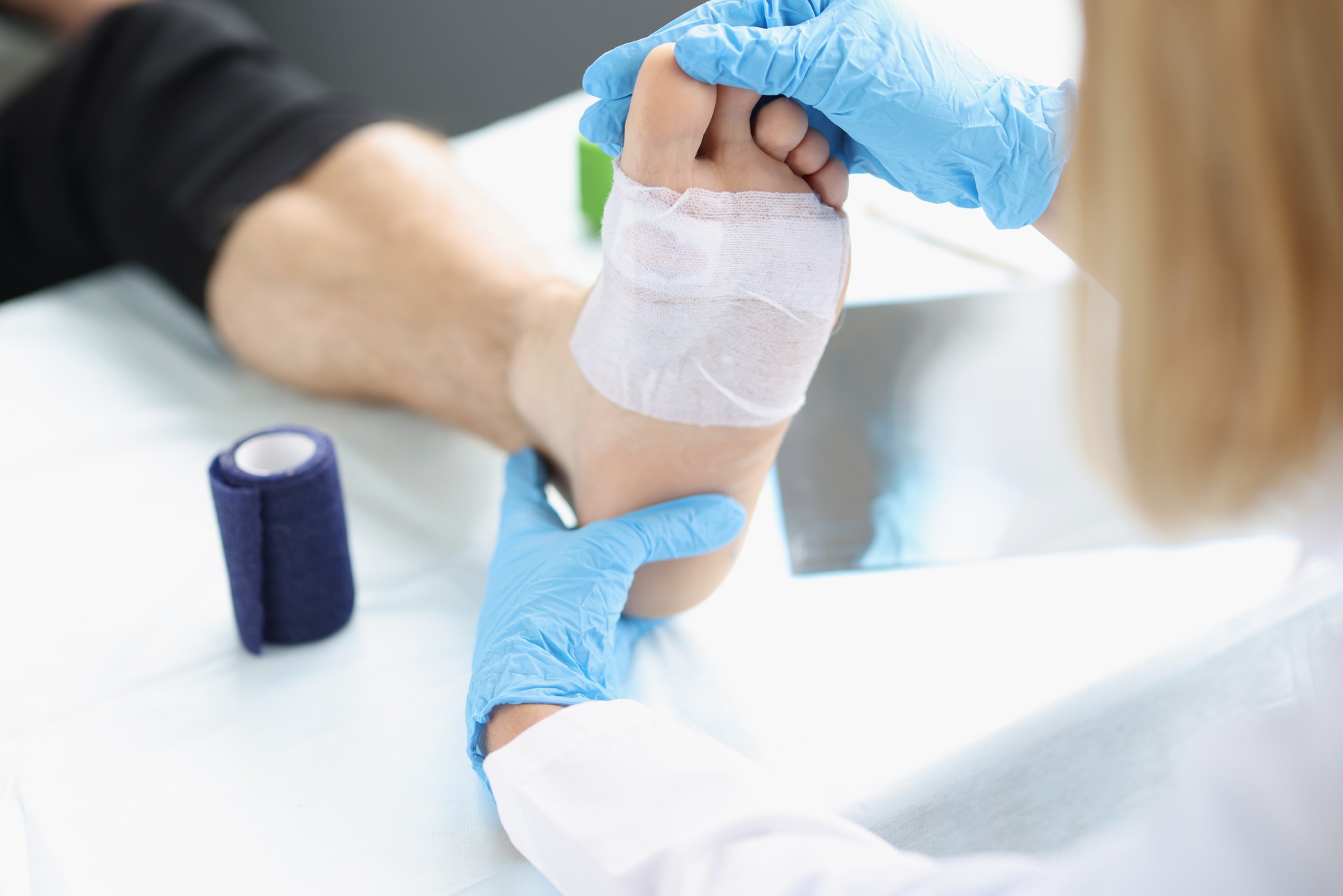 Doctor hand touches and examines wound on leg